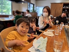 子どもを連れた家族が鉄板のついたテーブルで食事をしている写真